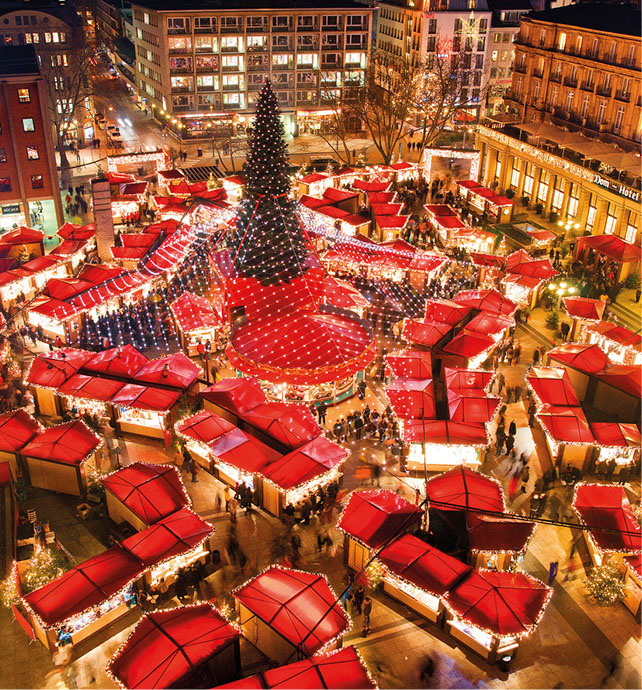 A bird’s-eye view of Cologne Christmas markets, Germany, filled with red tenst, a large Christmas tree, and twinkling lights