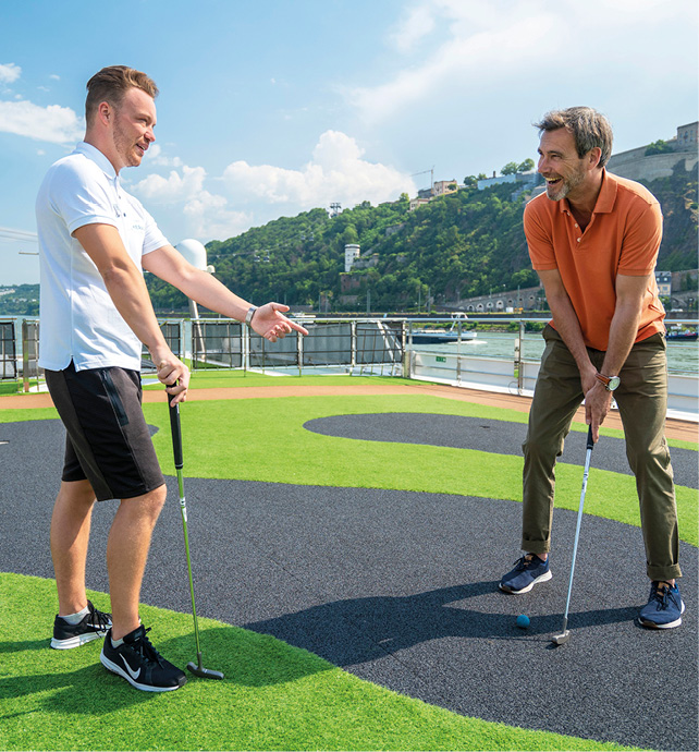 Friends playing golf on the putting green on the Sun Deck of a luxury river ship