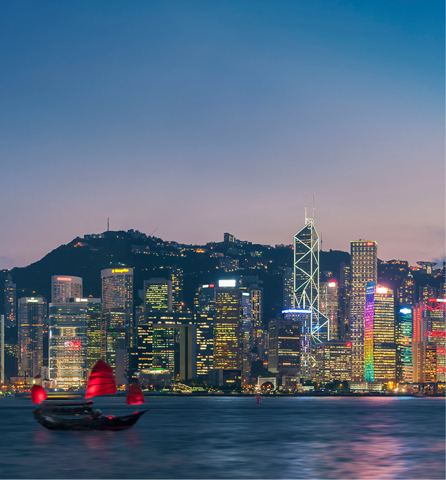 A nighttime cityscape of Victoria Harbour in Hong Kong